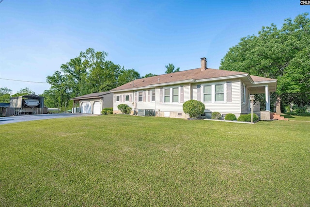 ranch-style home featuring a front lawn, a chimney, and aphalt driveway