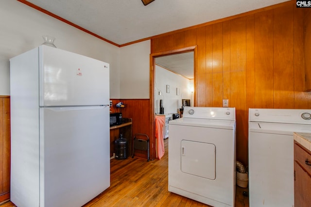 2700 Magnolia St, Columbia, SC 29204 - clothes washing area with washing machine and dryer, wainscoting, wood walls, light wood-style floors, and laundry area