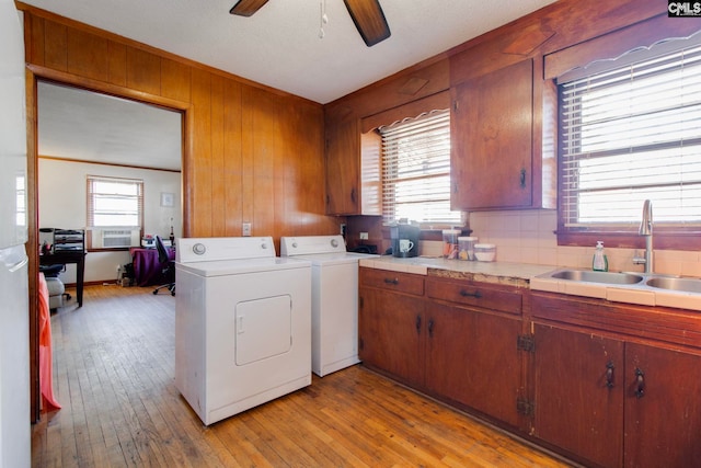 2700 Magnolia St, Columbia, SC 29204 - washroom with a sink, wood walls, light wood-type flooring, washer and dryer, and a ceiling fan