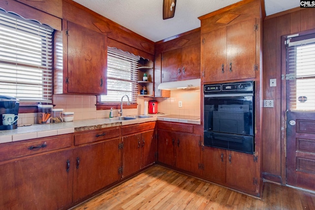 2700 Magnolia St, Columbia, SC 29204 - kitchen with a sink, black appliances, a warming drawer, under cabinet range hood, and decorative backsplash