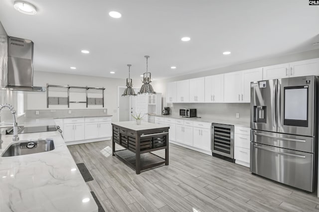 15 Glenlake Rd, Columbia, SC 29223 - kitchen with light wood finished floors, beverage cooler, stainless steel fridge, a sink, and wall chimney range hood