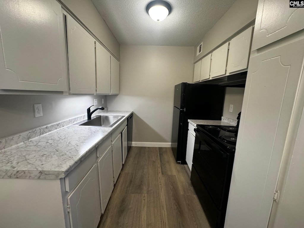 kitchen featuring a textured ceiling, a sink, black range with electric stovetop, dark wood-type flooring, and white cabinets