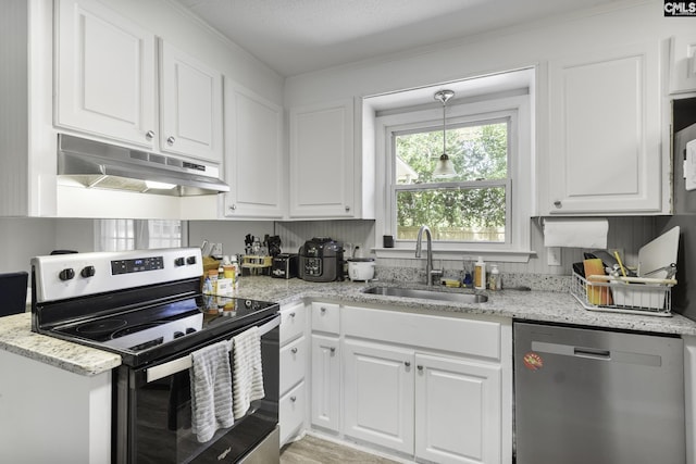 kitchen with light stone countertops, under cabinet range hood, a sink, white cabinetry, and stainless steel appliances