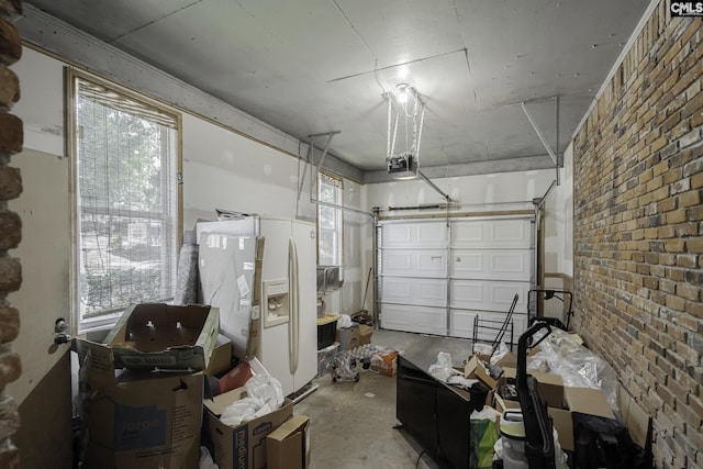 garage featuring white refrigerator with ice dispenser and a garage door opener
