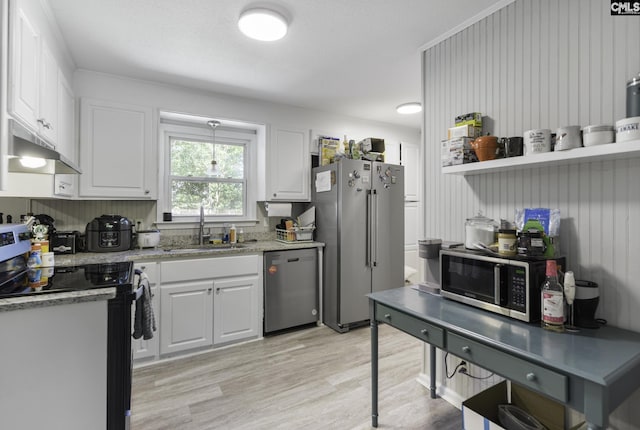 kitchen featuring under cabinet range hood, a sink, stainless steel appliances, white cabinets, and light wood-type flooring