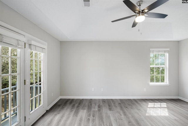 spare room with visible vents, plenty of natural light, and wood finished floors