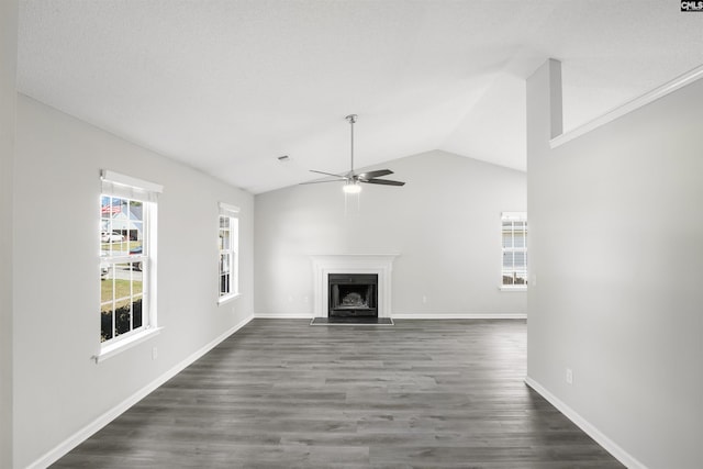 unfurnished living room with a ceiling fan, a fireplace with flush hearth, baseboards, lofted ceiling, and dark wood-style floors