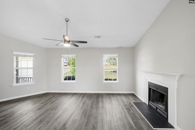 unfurnished living room featuring a ceiling fan, a fireplace, visible vents, baseboards, and dark wood-style floors