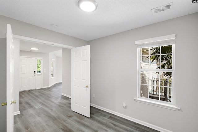 spare room featuring visible vents, wood finished floors, and baseboards
