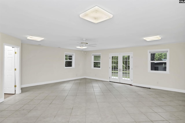 empty room featuring light tile patterned floors, baseboards, a ceiling fan, and french doors