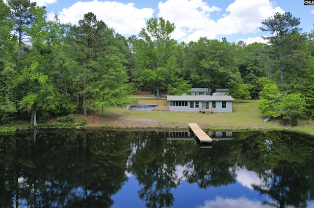 view of water feature featuring a wooded view and a dock