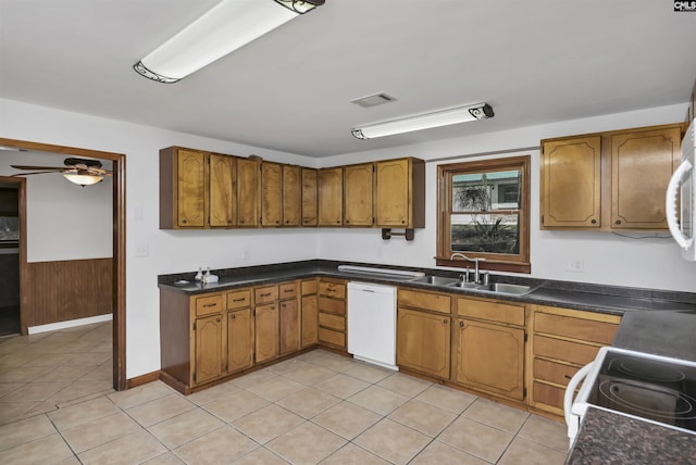 kitchen featuring visible vents, brown cabinetry, a sink, and white appliances