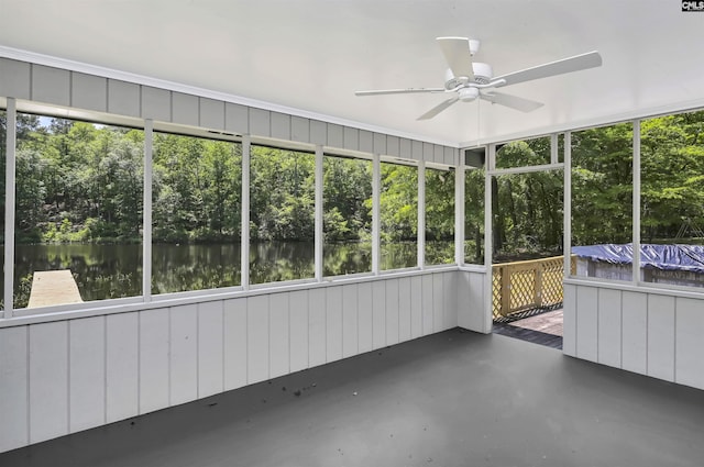 unfurnished sunroom with a water view, a ceiling fan, and a wealth of natural light