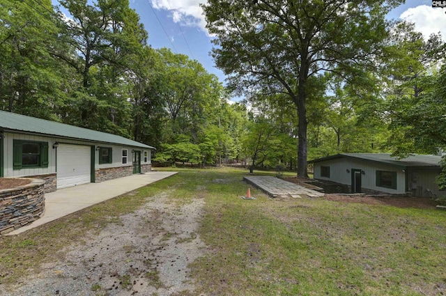 view of yard featuring concrete driveway and an attached garage