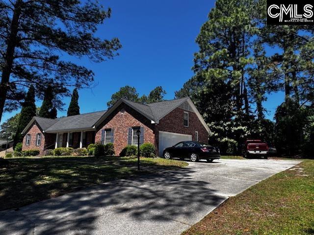 204 E Springs Rd, Columbia, SC 29223 - view of side of property with concrete driveway, brick siding, an attached garage, and a yard
