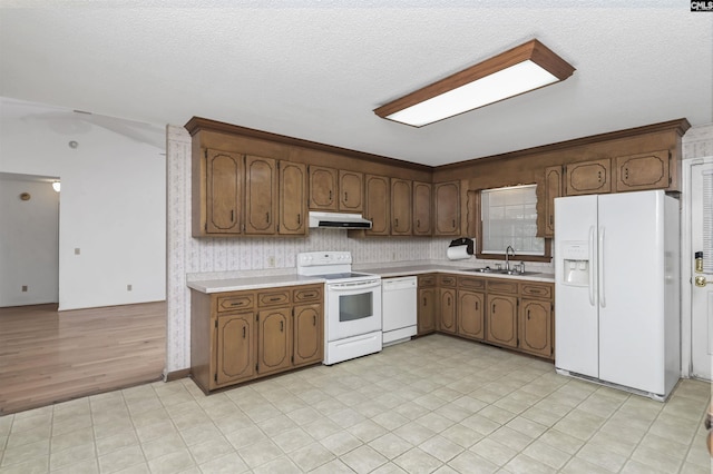 kitchen featuring white appliances, light countertops, a sink, and under cabinet range hood