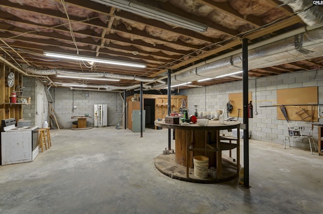 unfinished below grade area with concrete block wall and washer / clothes dryer