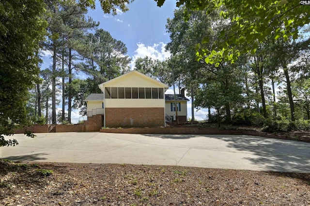 exterior space with a sunroom and brick siding