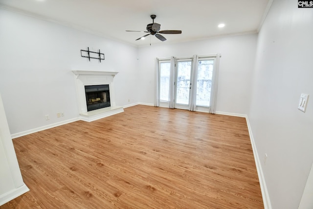 unfurnished living room featuring baseboards, light wood-style floors, ceiling fan, and a fireplace with raised hearth