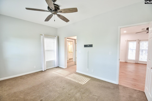 unfurnished bedroom with light colored carpet, baseboards, and ceiling fan