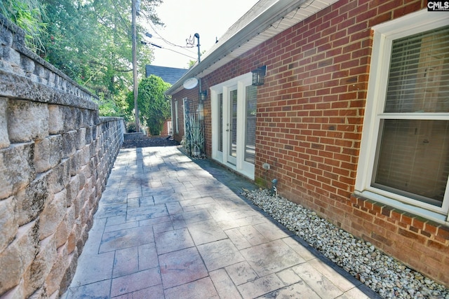 view of property exterior featuring a patio area and brick siding