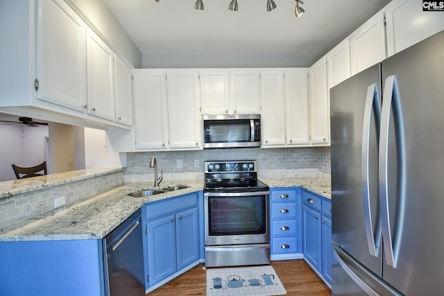 kitchen featuring a sink, white cabinetry, appliances with stainless steel finishes, blue cabinets, and dark wood-style floors