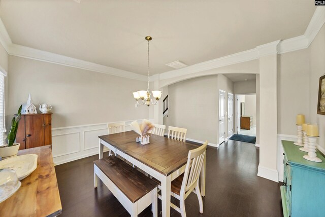 dining area featuring an inviting chandelier, ornamental molding, arched walkways, and a wainscoted wall