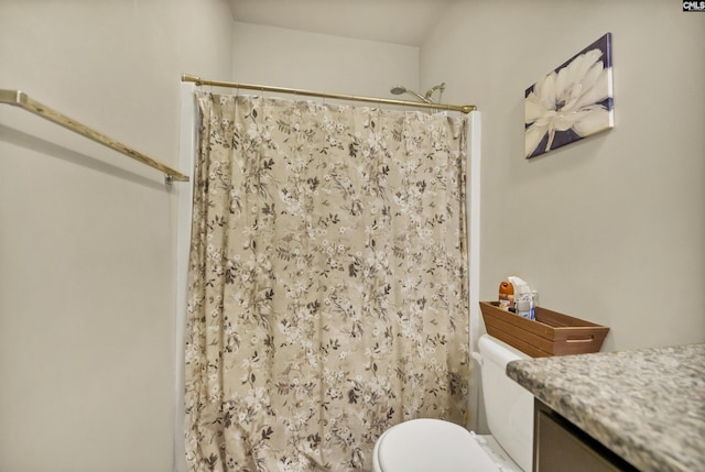 bathroom featuring toilet, curtained shower, and vanity