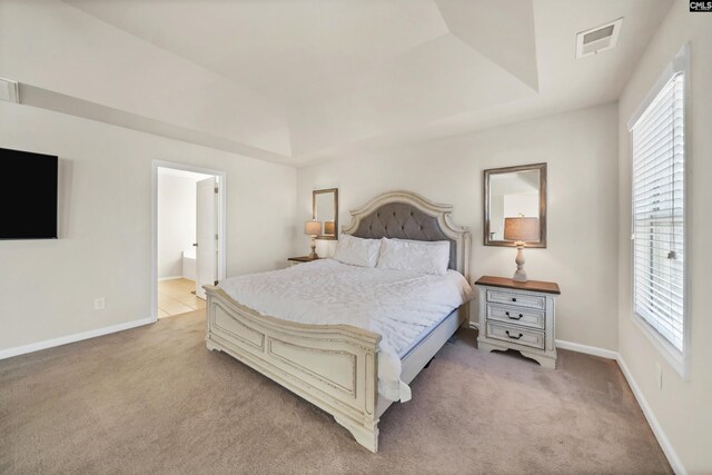 bedroom featuring light colored carpet, connected bathroom, visible vents, and baseboards