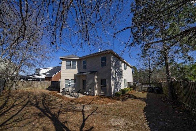 rear view of property featuring a fenced backyard and a patio area