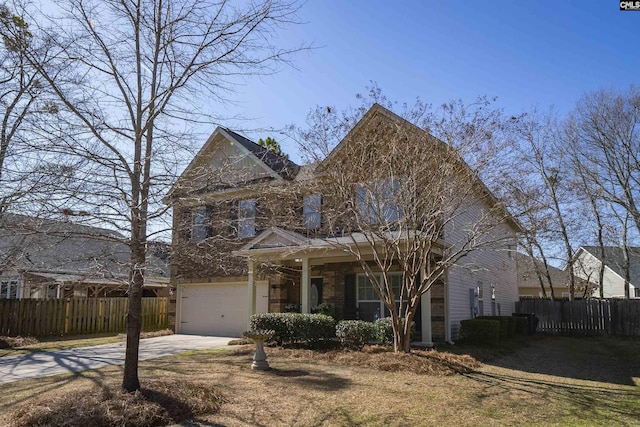 view of front of home with fence, a garage, and driveway