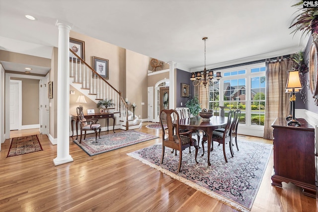 212 Cartgate Cir, Blythewood, SC 29016 - dining room with an inviting chandelier, wood finished floors, decorative columns, baseboards, and stairs