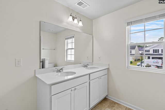 full bath featuring baseboards, toilet, double vanity, and tile patterned flooring