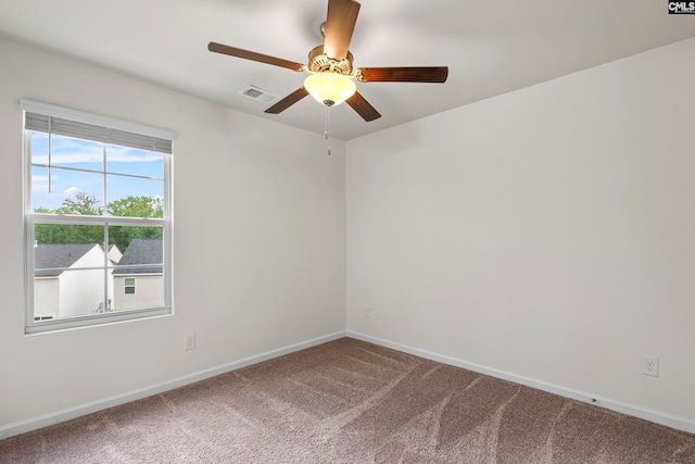 empty room featuring carpet flooring, baseboards, and a ceiling fan