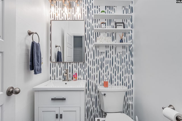 half bath with toilet, a chandelier, and vanity