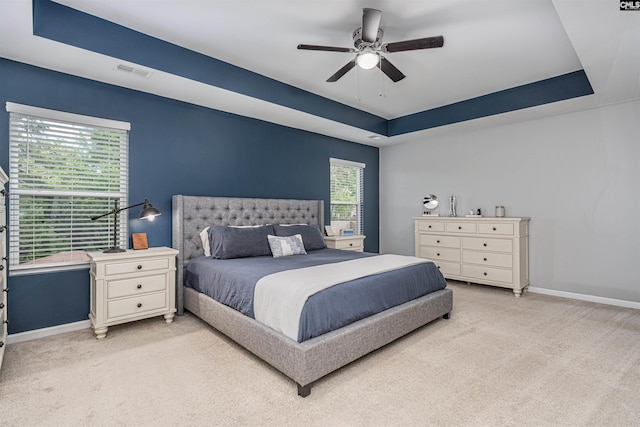 bedroom with light colored carpet, baseboards, and multiple windows