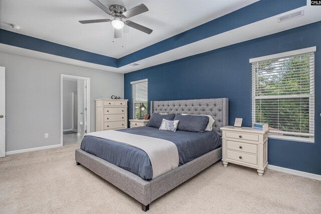 bedroom with light colored carpet, baseboards, and a ceiling fan