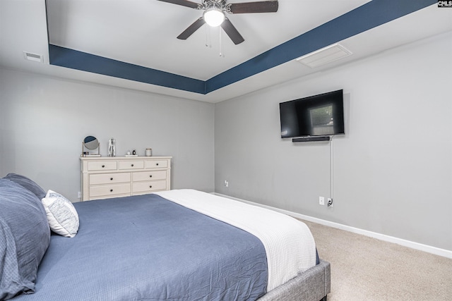 bedroom featuring carpet floors, baseboards, ceiling fan, and a tray ceiling