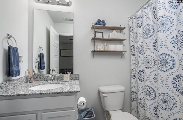 bathroom with toilet, vanity, and a shower with curtain