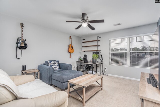 living room featuring a ceiling fan, light colored carpet, and baseboards