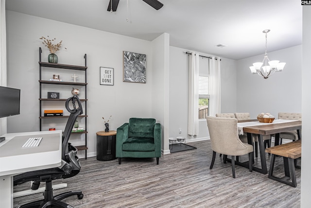 dining room featuring wood finished floors, a chandelier, an office area, a ceiling fan, and baseboards