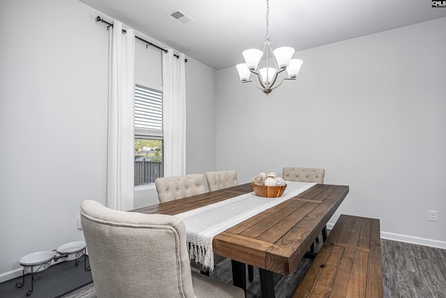 dining area with a chandelier, wood finished floors, and baseboards