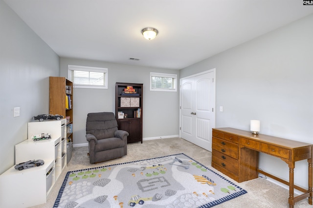 living area featuring light colored carpet, baseboards, and an office area
