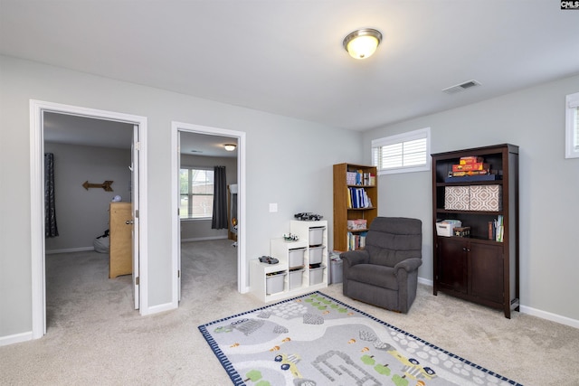 living area with light colored carpet, healthy amount of natural light, and baseboards