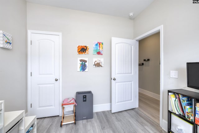game room featuring light wood finished floors and baseboards