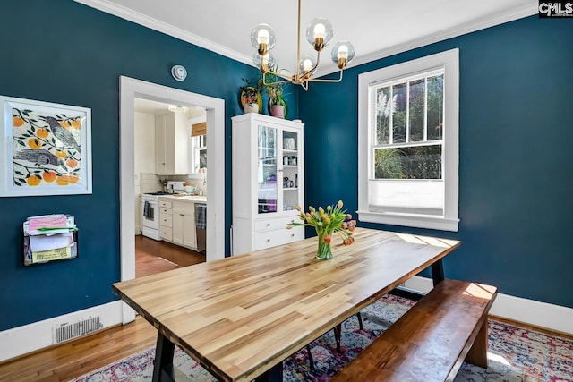 307 Waccamaw Ave, Columbia, SC 29205 - dining room with a chandelier, baseboards, ornamental molding, and wood finished floors