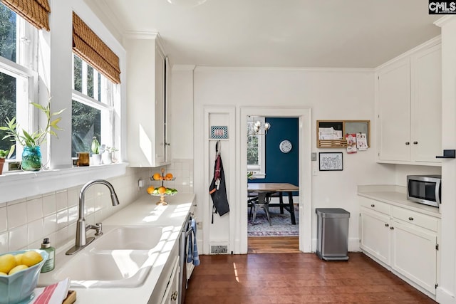 307 Waccamaw Ave, Columbia, SC 29205 - kitchen featuring stainless steel microwave, a sink, dark wood-style flooring, backsplash, and crown molding