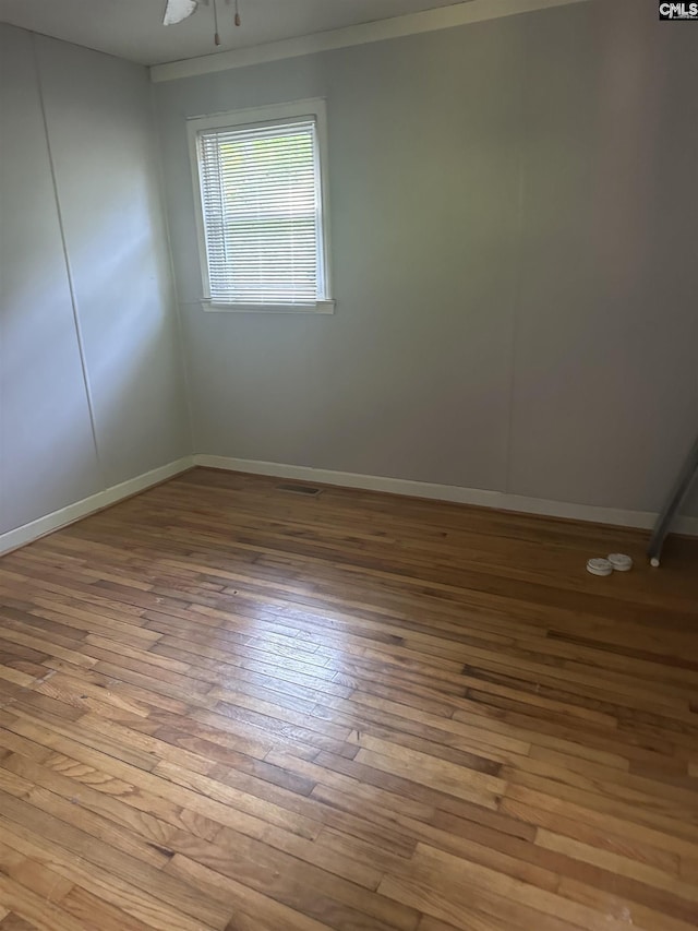 unfurnished room with hardwood / wood-style flooring and baseboards