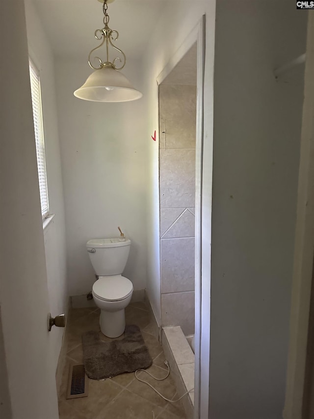 bathroom featuring tile patterned floors, toilet, and a shower