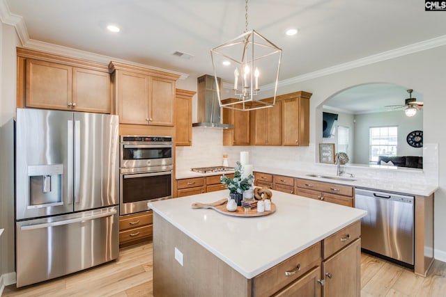 kitchen featuring appliances with stainless steel finishes, range hood, a sink, arched walkways, and backsplash
